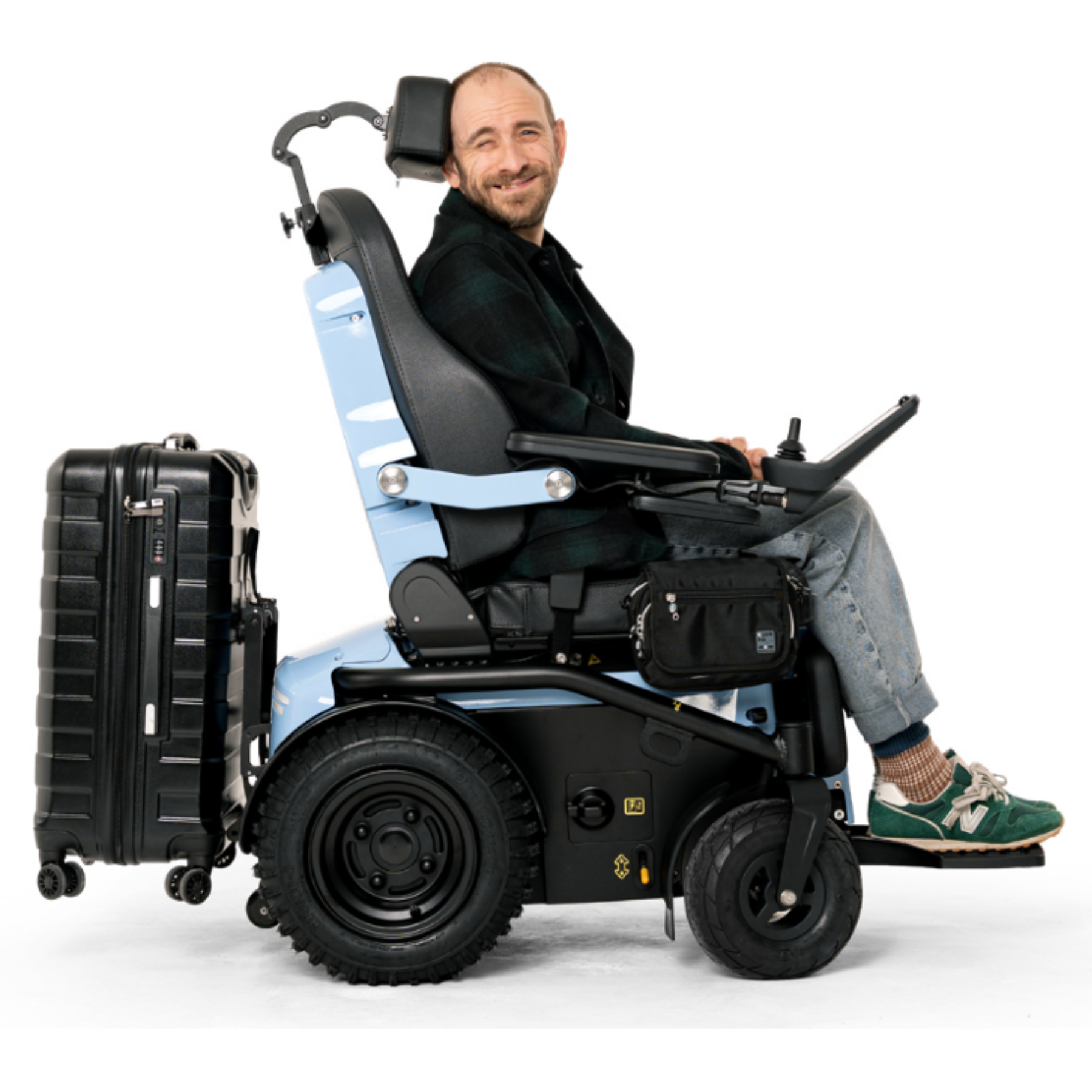 Man in a light blue Series 5 powerchair with a suitcase mounted on the luggage carrier